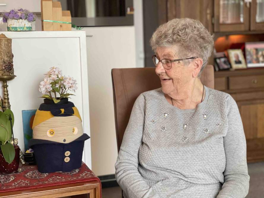 Oudere dame kijkt lachend naar haar Tessa-zorgrobot