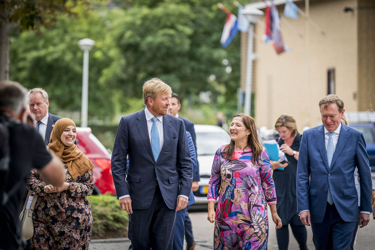 Koning Willem Alexander en minister Bruins maken een wandeling door de wijk met twee gezondheidsambassadeurs