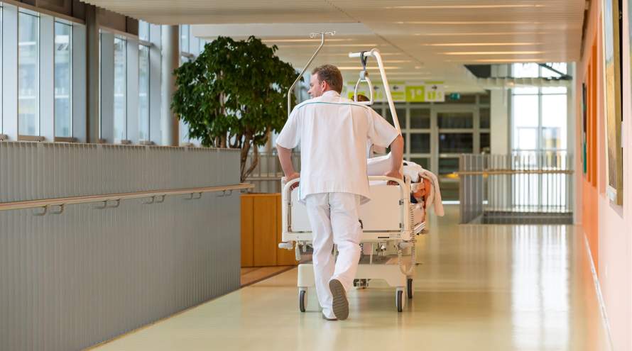 Verpleegkundige verplaatst bed in ziekenhuis