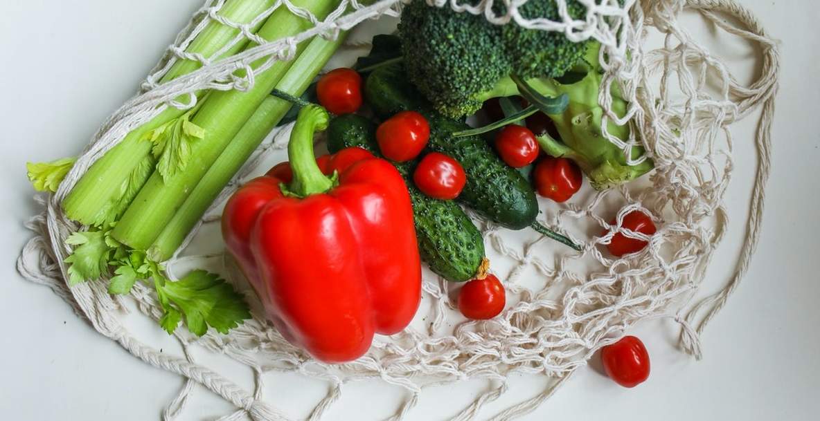 Boodschappentasje met bleekselderij, paprika, broccolu en tomaten