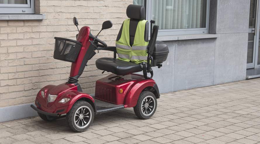 Lege scootmobiel voor een gevel geparkeerd