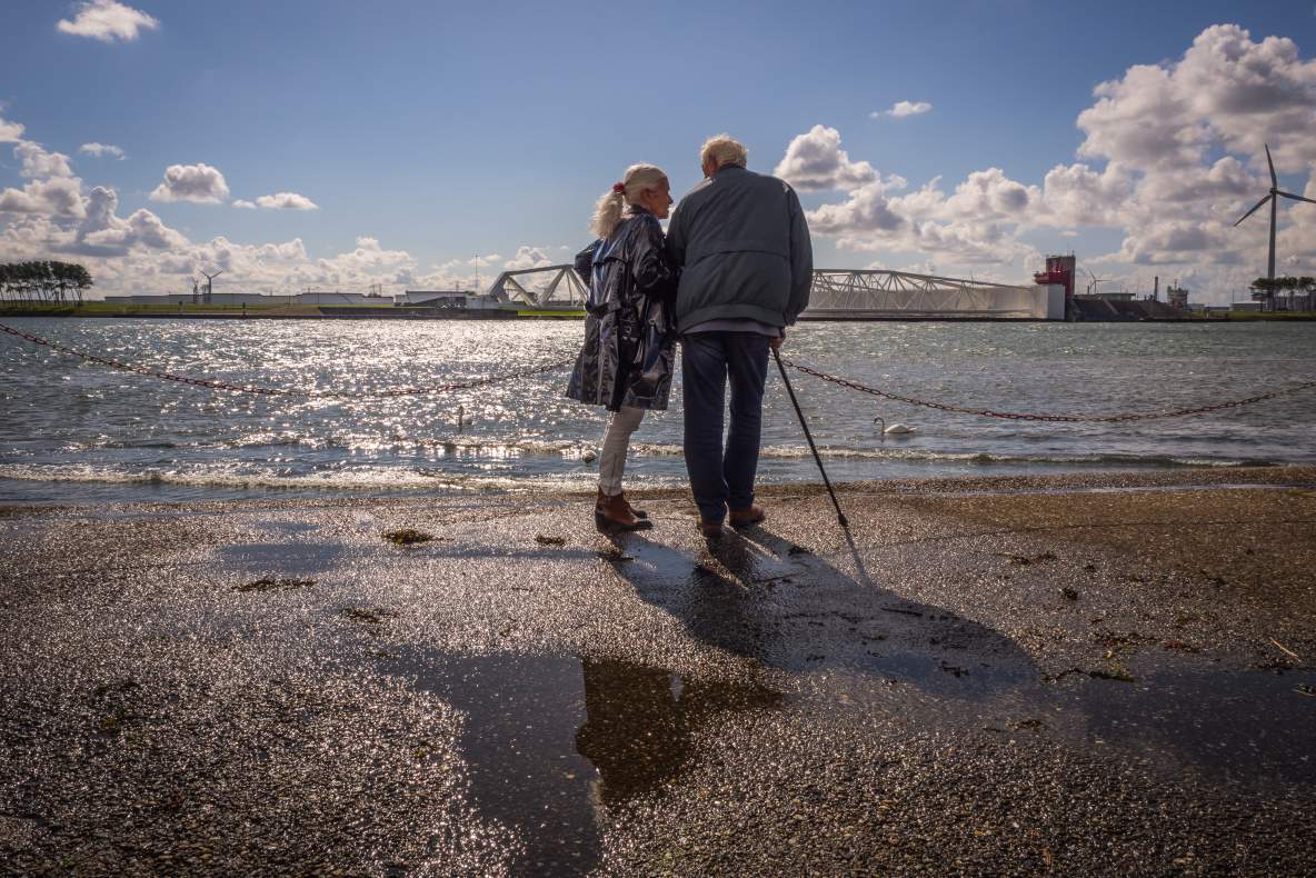 Een ouder koppel staat samen aan het water