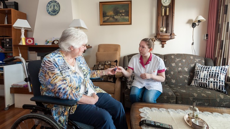 Een wijkverpleegkundige praat met een cliënt