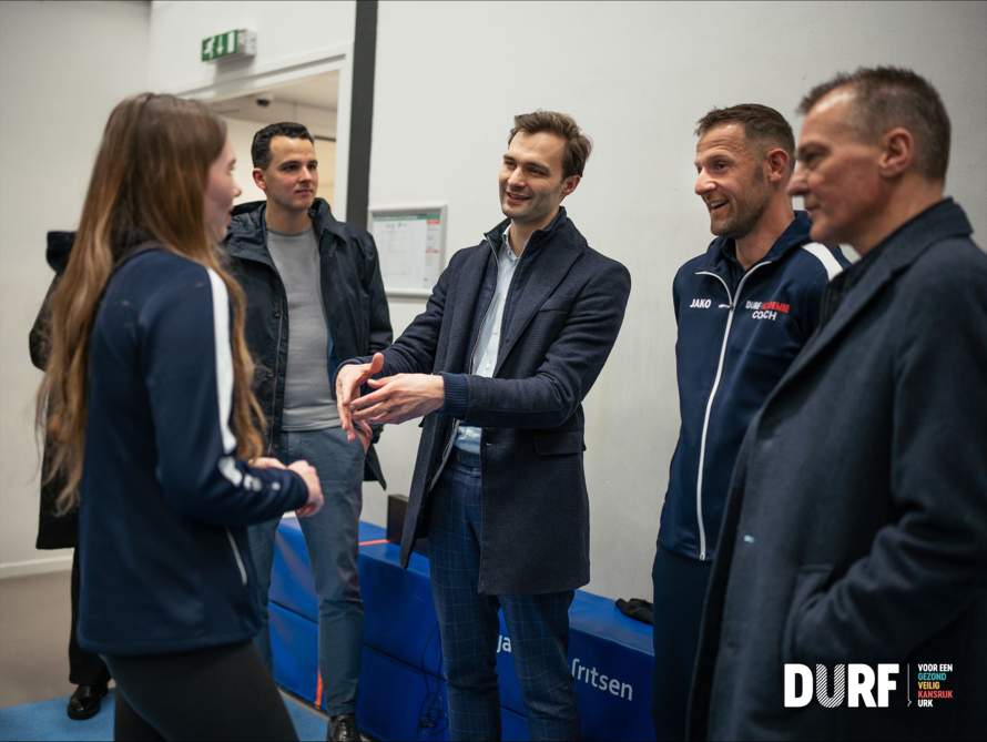 Staatssecretaris Maarten van Ooijen in gesprek met een DURF-coach en een deelnemer aan het programma