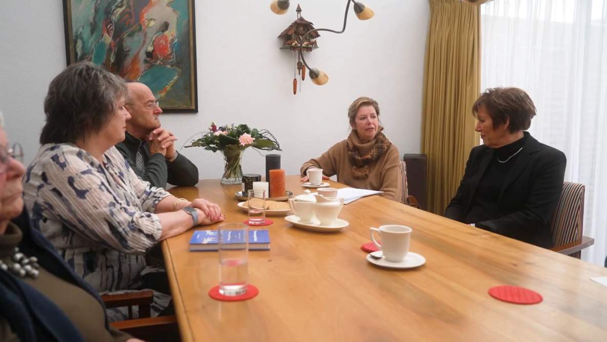 Leden van een voorzorgcirkel aan tafel in gesprek
