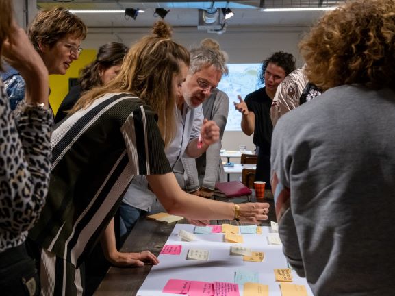 Deelnemers bestuderen geeltjes met ideeën