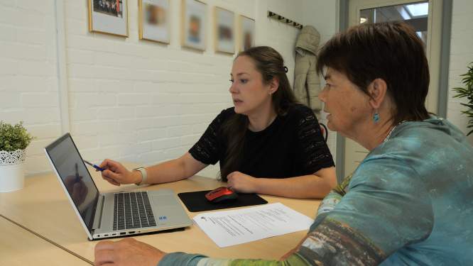 Cliënt met hulpverlener kijken naar laptop