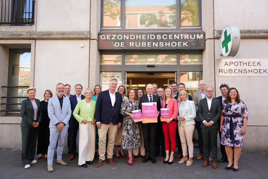 Minister Bruin van VWS poseert met de bestuurders van zorg- en welzijnsorganisaties na de ondertekening van het AZWA